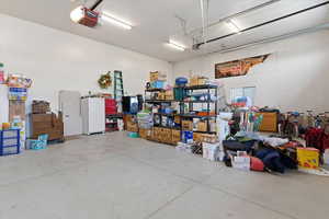 Garage with freestanding refrigerator and a garage door opener