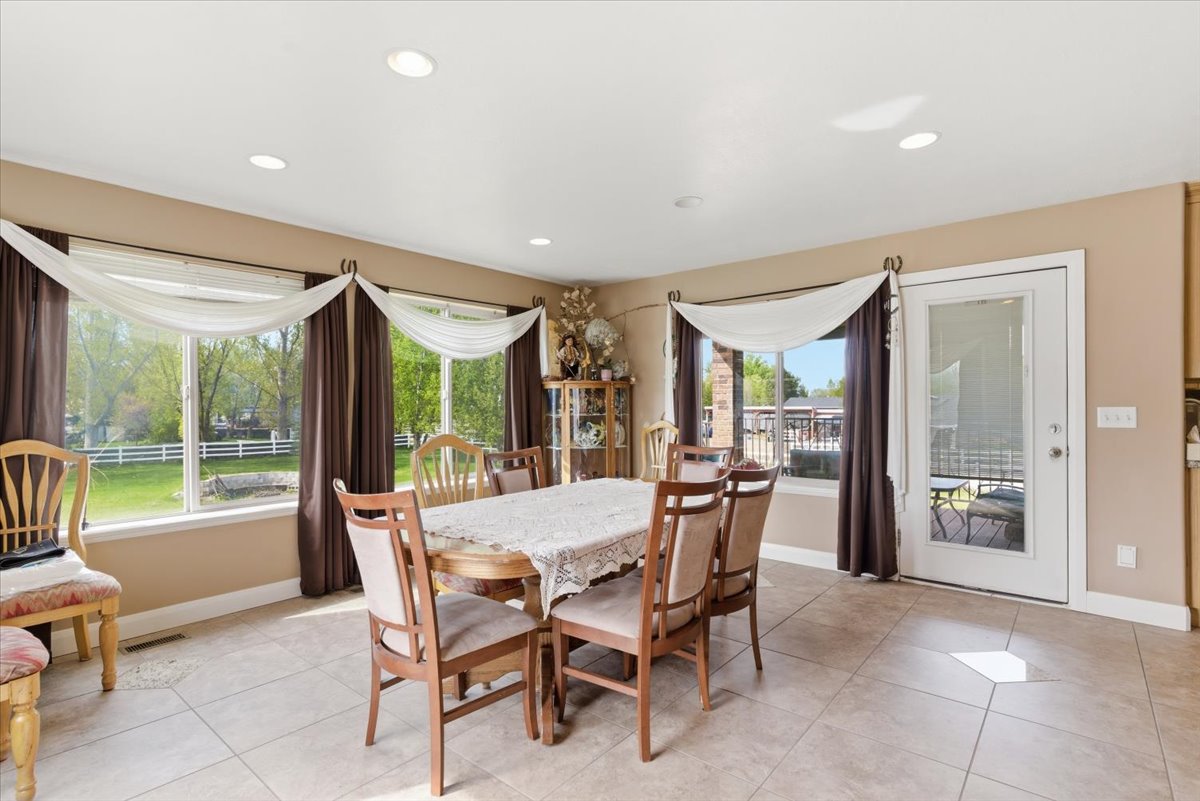 Dining area with light tile patterned floors and recessed lighting