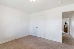Unfurnished bedroom featuring light colored carpet and a closet