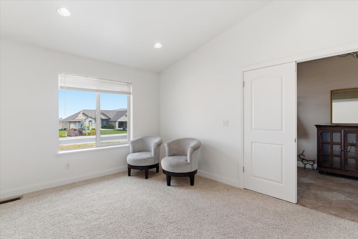 Living area featuring vaulted ceiling, light carpet, and recessed lighting