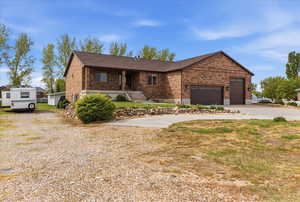 Ranch-style house featuring brick siding, concrete driveway, covered porch, a garage, and a shingled roof