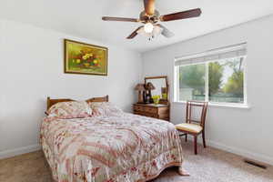 Bedroom with light colored carpet and a ceiling fan