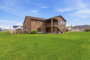 Rear view of property featuring a patio, brick siding, and a balcony
