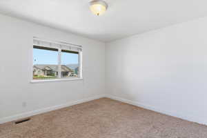 Empty room featuring baseboards and carpet flooring
