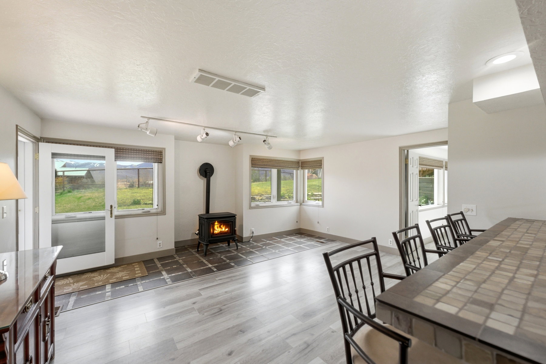 Dining space featuring a wood stove, a textured ceiling, and light wood-type flooring