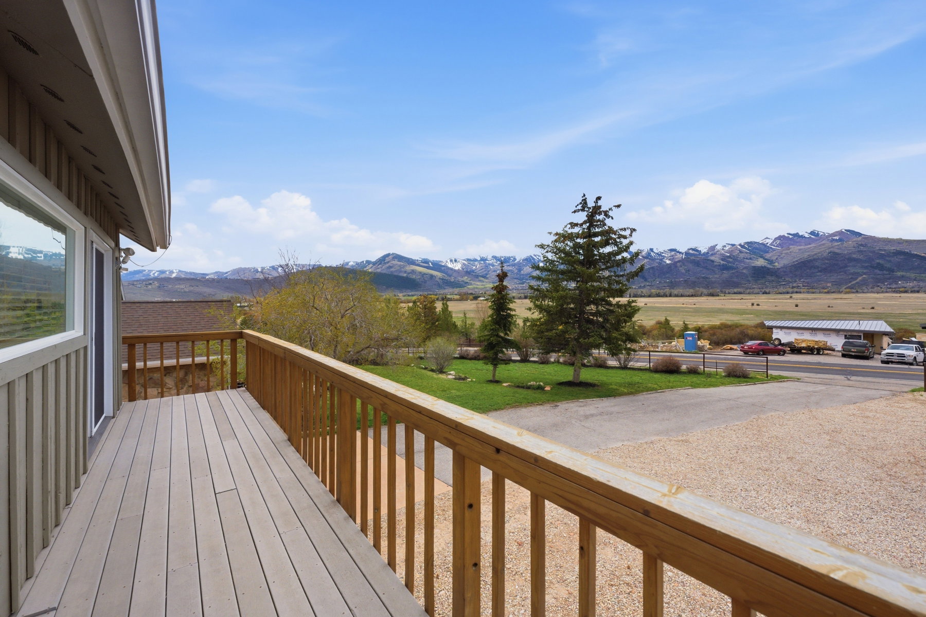 Wooden deck with a mountain view, a view of rural / pastoral area, and a yard
