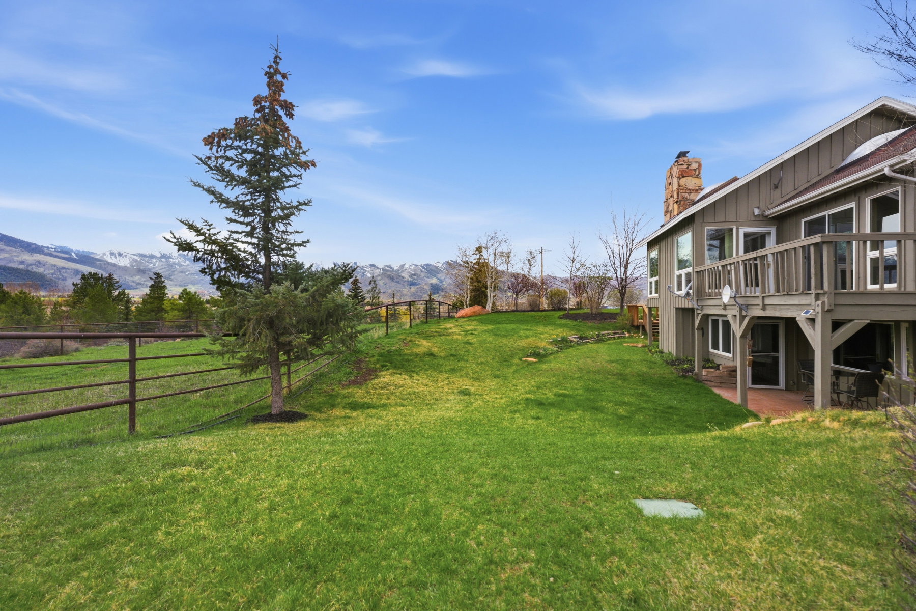View of yard featuring a deck with mountain view and a patio area