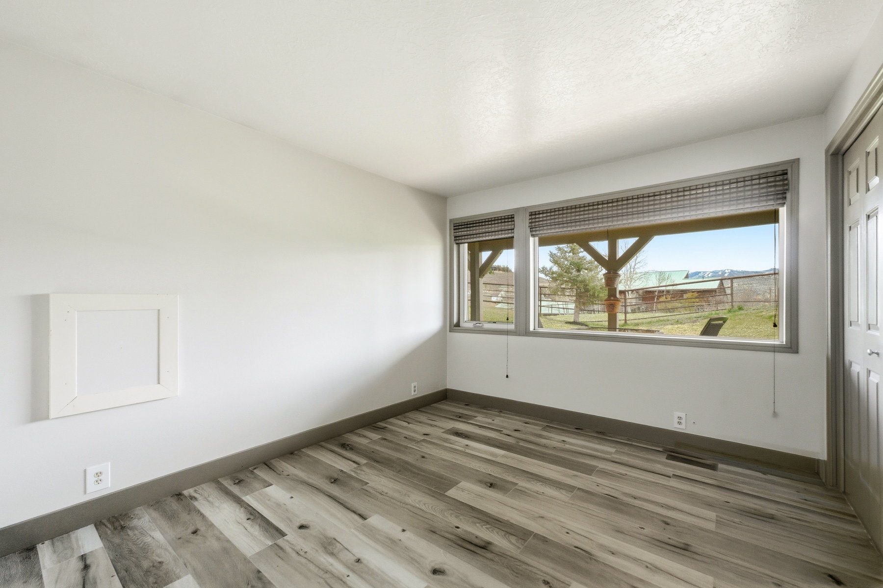 Spare room featuring light wood-style floors and baseboards