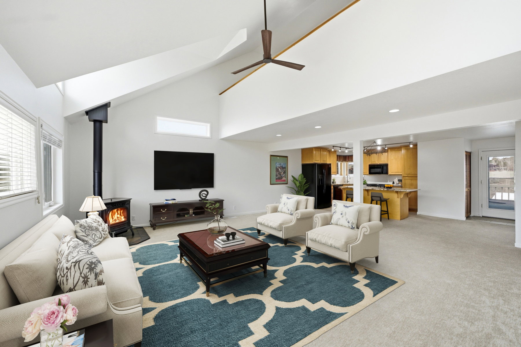 Living area with a wood stove, light colored carpet, lofted ceiling, a ceiling fan, and recessed lighting