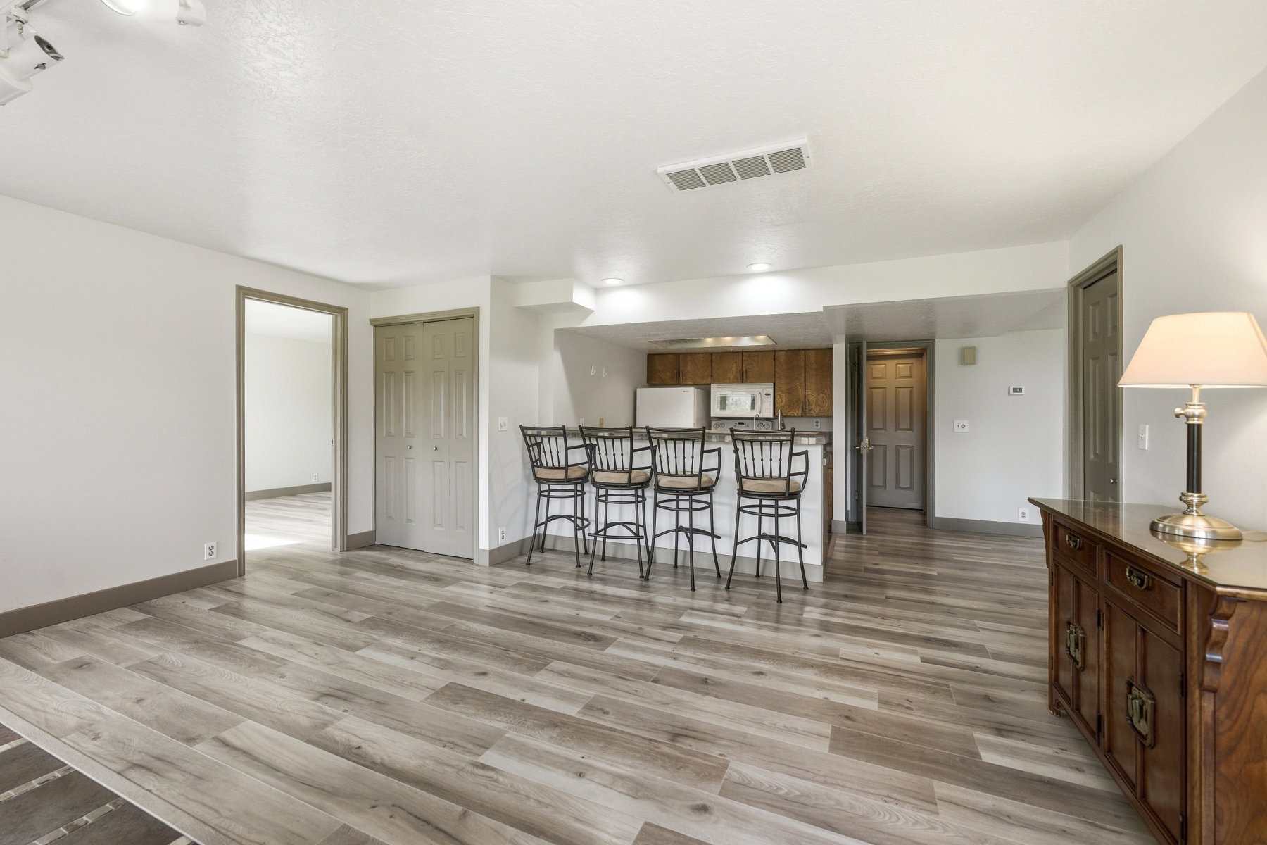 Kitchen with a kitchen breakfast bar, light wood-type flooring, white appliances, wood finish cabinets, and a peninsula