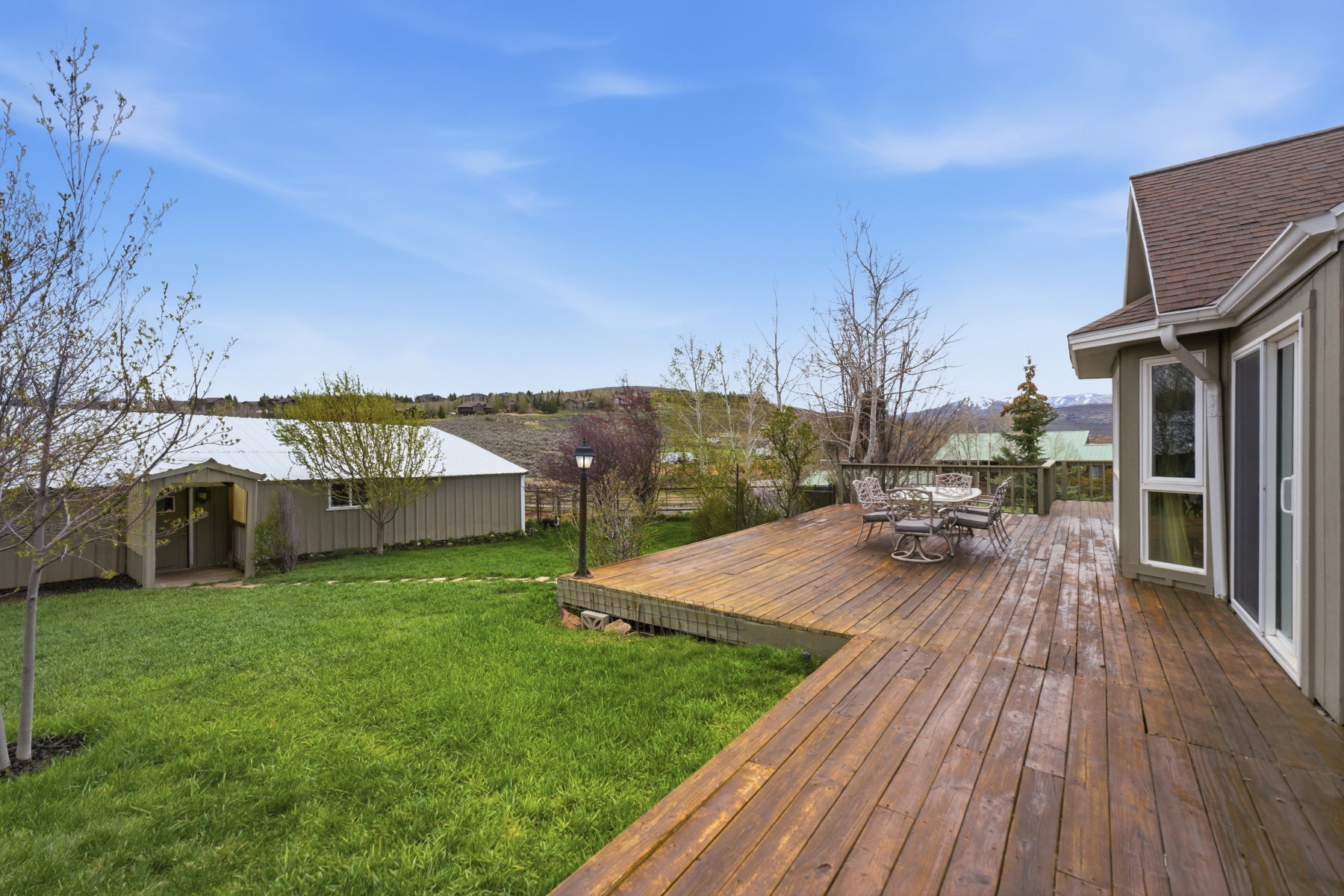Wooden deck featuring outdoor dining area and a lawn