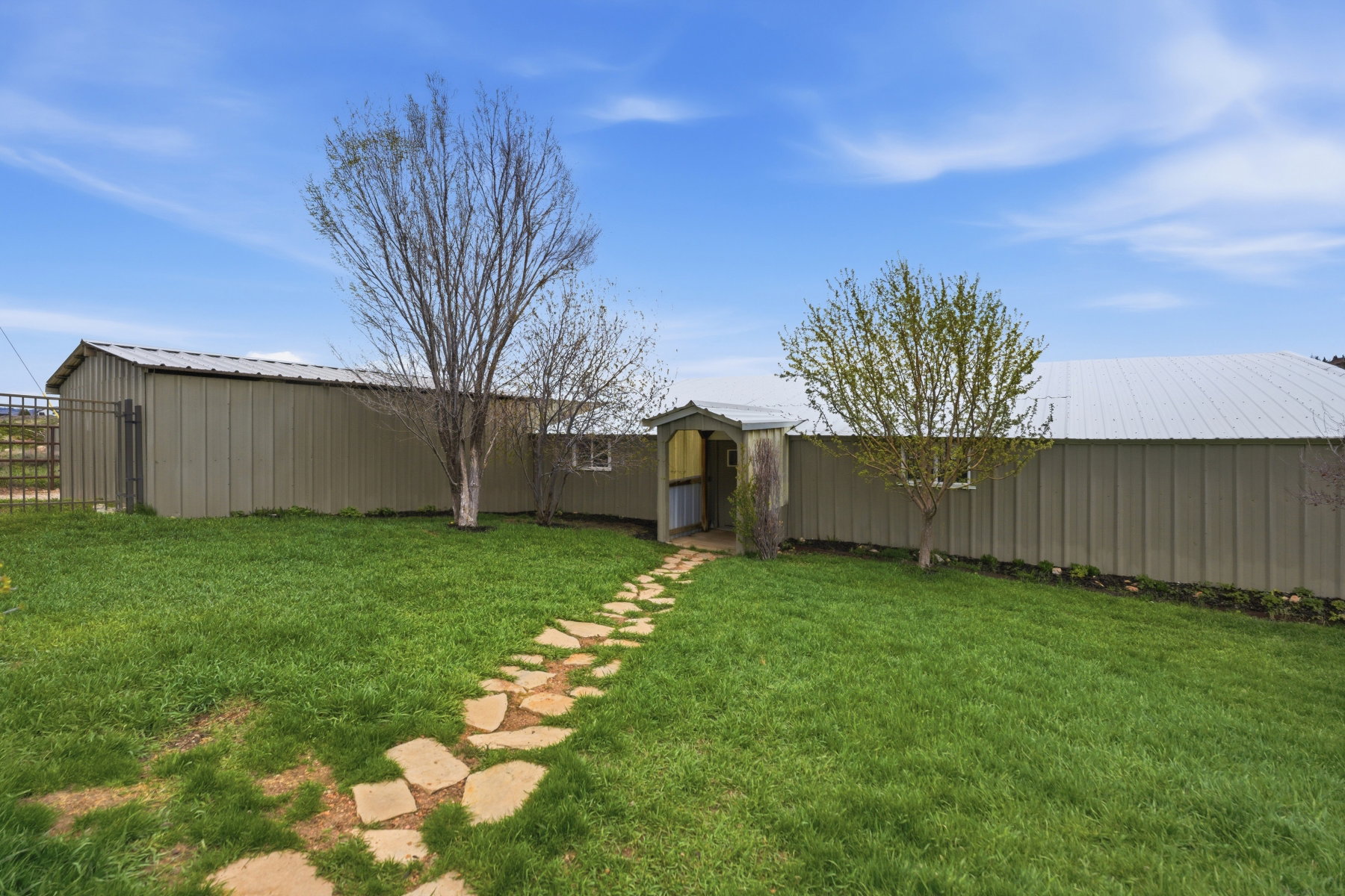 View of grassy yard with an outbuilding and an outdoor structure