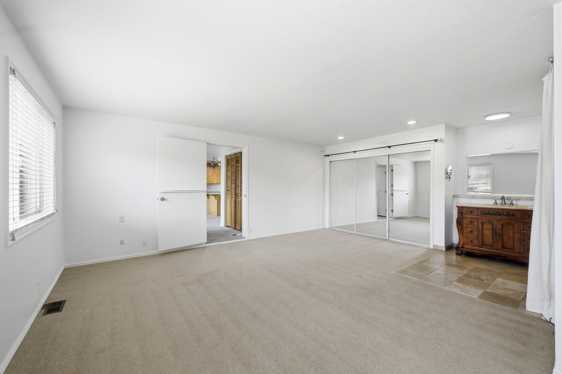 Unfurnished bedroom with light carpet, multiple windows, and a closet