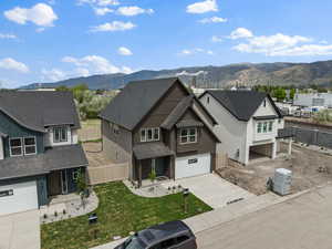 View of front of home featuring a mountain view, driveway, a porch, an attached garage, and roof with shingles
