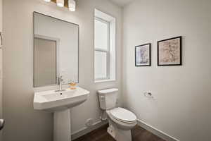 Bathroom featuring toilet and dark wood-style flooring