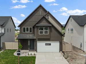 View of front of home with board and batten siding, driveway, a garage, and a residential view