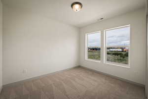 Carpeted empty room featuring baseboards