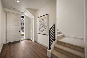 Entryway with dark wood-style floors and stairway