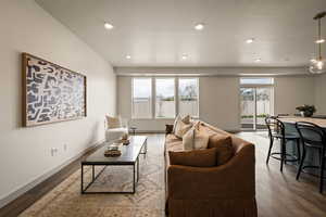 Living room featuring dark wood-style floors, recessed lighting, and a textured ceiling