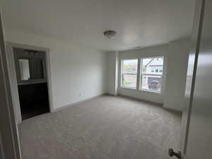 Unfurnished room with light colored carpet and baseboards