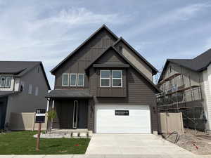 View of front of property with a garage, board and batten siding, and concrete driveway