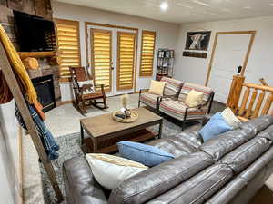 Living room featuring carpet, a fireplace, and recessed lighting