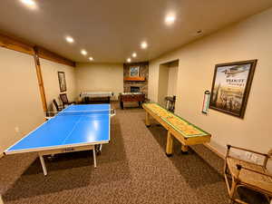 Rec room with a fireplace, dark colored carpet, and recessed lighting