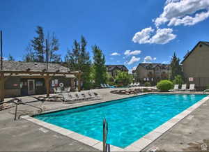 Community pool featuring a patio area, a pergola, and a residential view