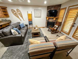 Living room featuring a fireplace, light carpet, and recessed lighting