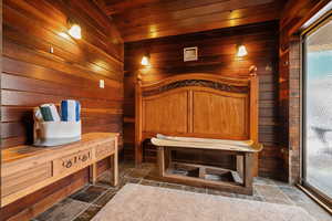 Interior space plumbed  for a sauna,  with solid wood walls, and slate flooring.