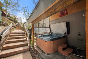 View of patio / terrace with stairs and a hot tub.