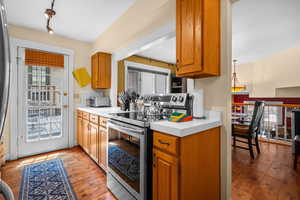 Kitchen with stainless steel appliances, light countertops, and lots of natural light.