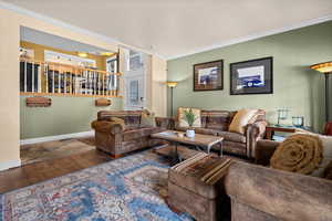 Spacious family room featuring french doors, LVP flooring, crown molding, and wood fireplace.