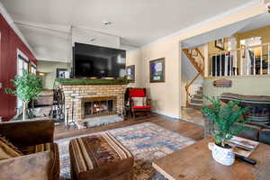 Spacious family room featuring french doors, LVP flooring, crown molding, and wood fireplace.