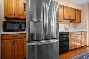 Kitchen featuring stainless steel fridge, solid wood cabinetry, and new kitchen faucet.