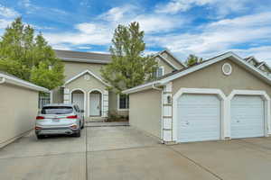 Traditional-style house with stucco siding, concrete driveway, and a garage