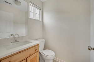 Half bathroom with vanity and toilet