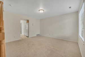 Unfurnished room featuring light colored carpet and baseboards