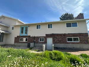 Rear view of property featuring brick siding and a patio