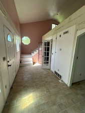 Entrance foyer with plenty of natural light, vaulted ceiling, and light floors