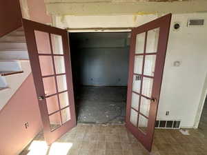 Hallway featuring stairway and french doors