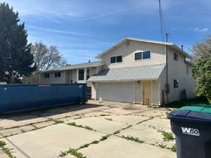 View of front of property featuring a garage and concrete driveway