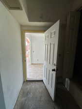 Hall with concrete flooring and attic access