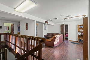Living area featuring attic access and wood finished floors