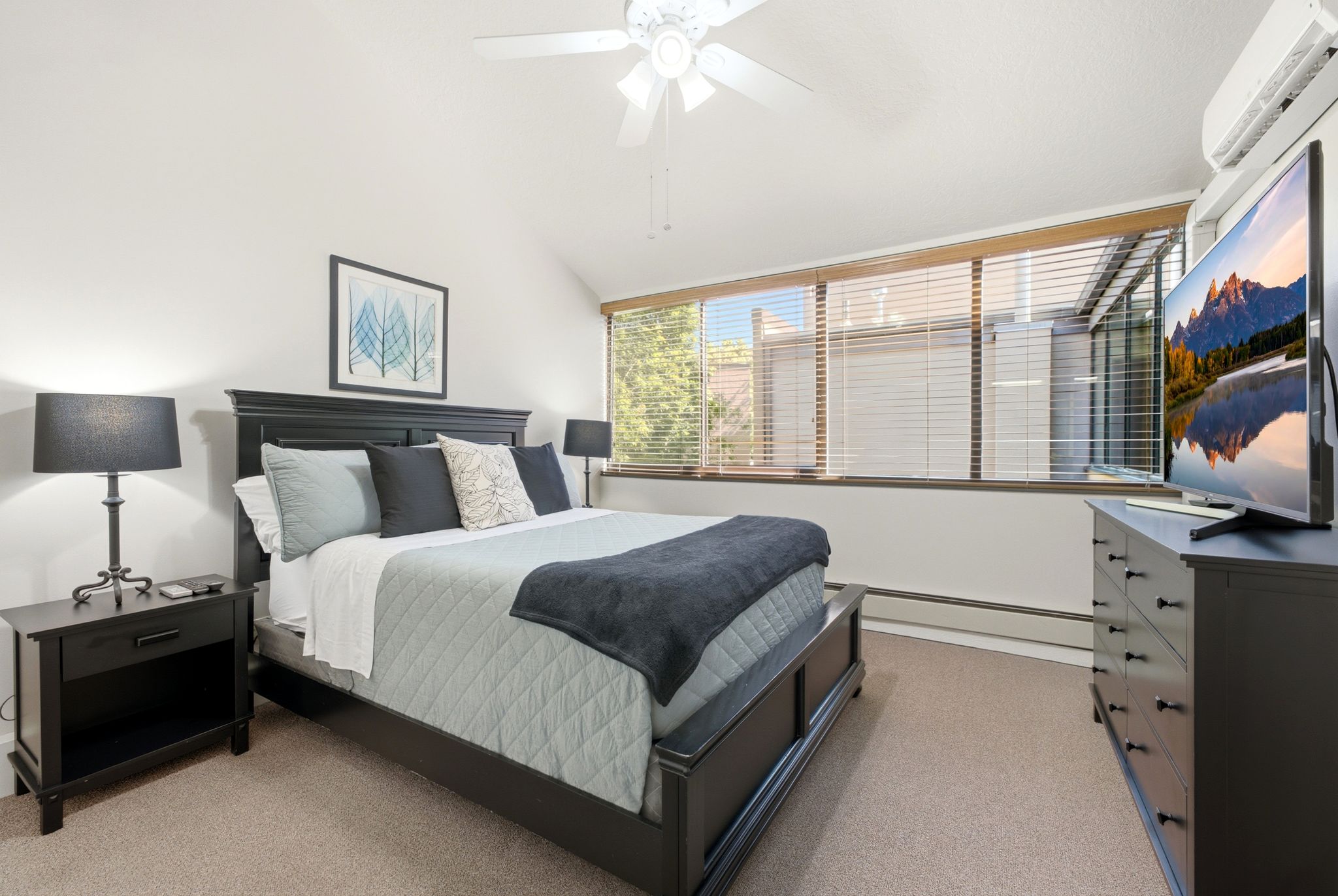 Carpeted room with a vaulted ceiling and a ceiling fan