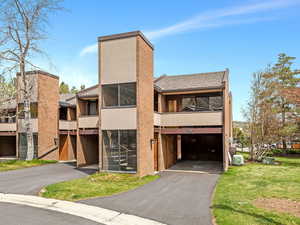 View of front of home featuring roof with shingles and a balcony