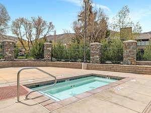 View of swimming pool featuring a hot tub, a swimming pool, patio surround, and a mountain view