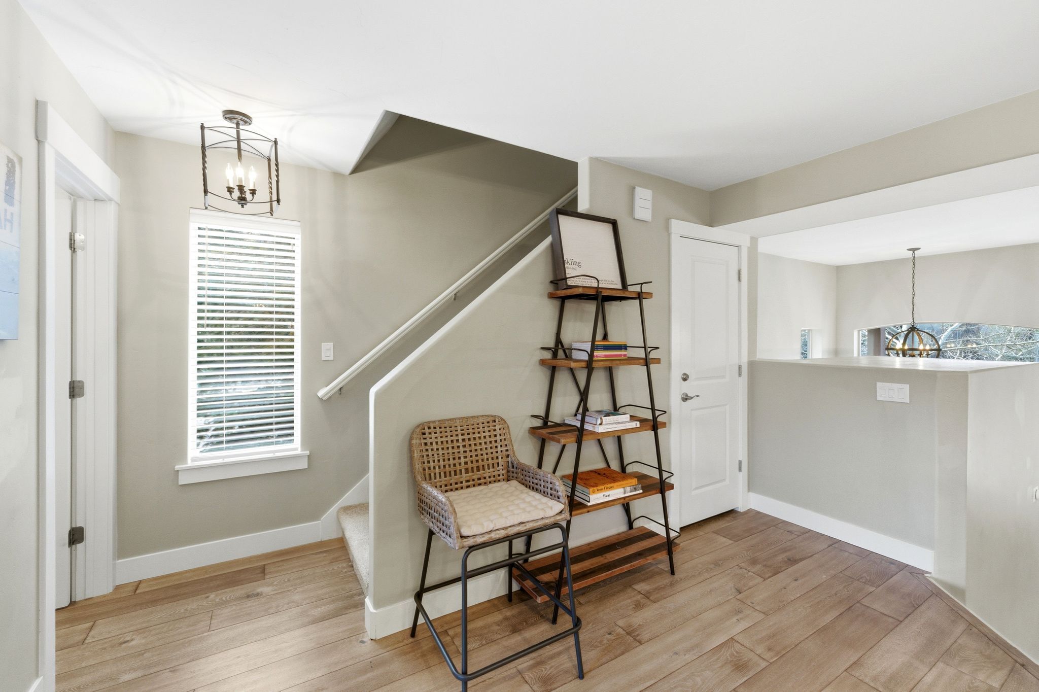 Sitting room with hanging lights and light wood-style floors