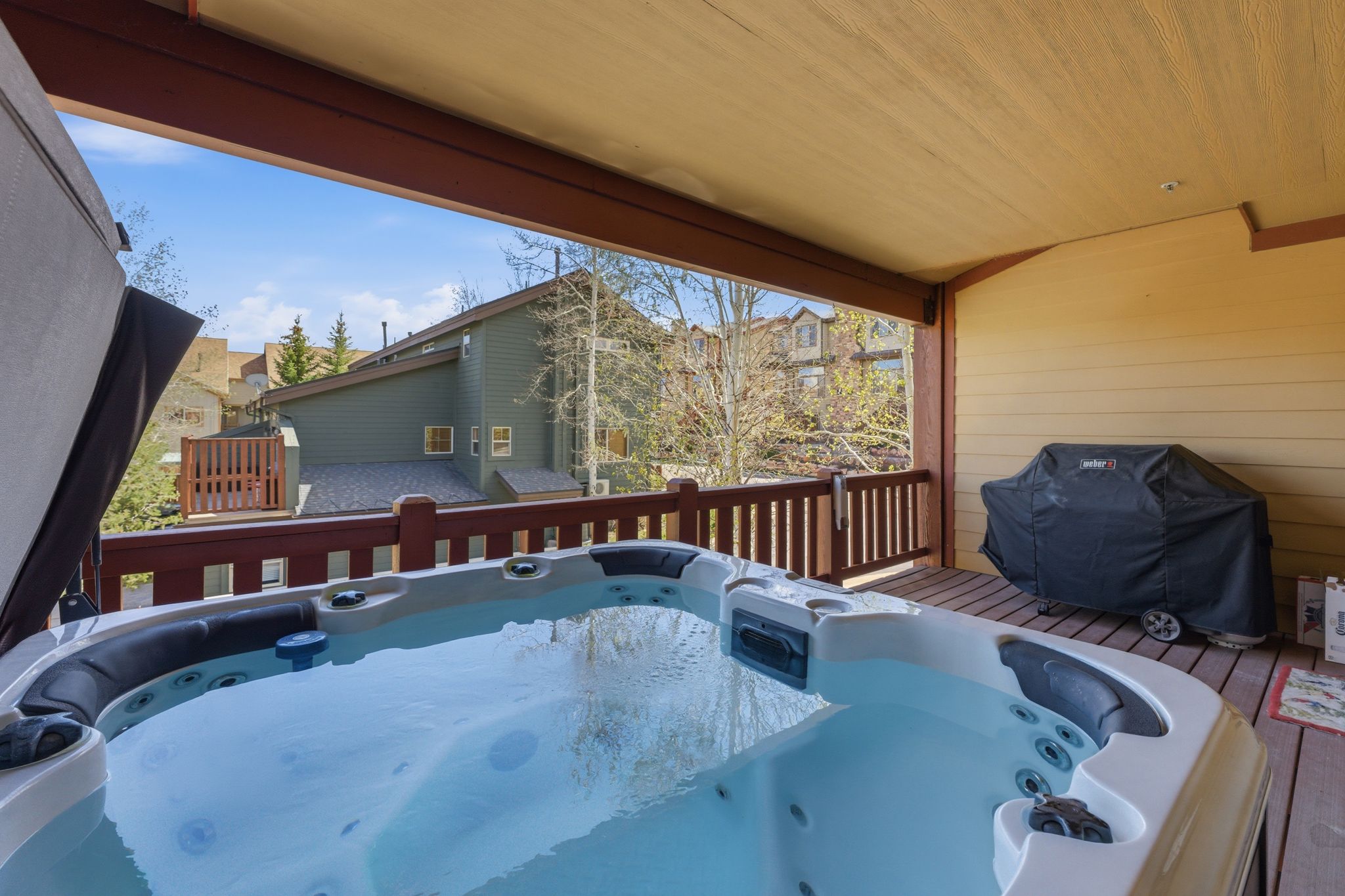 Wooden deck with a hot tub and grilling area