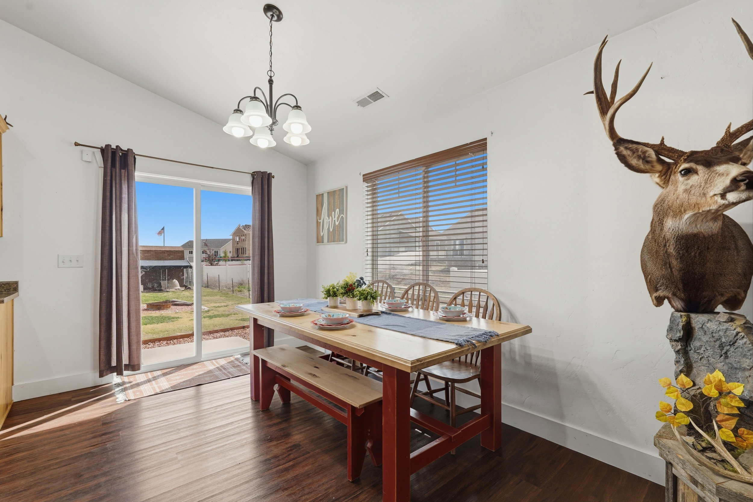 Dining area featuring vaulted ceiling, dark wood-style flooring, and hanging lights